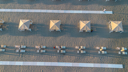 Sun umbrellas and sun loungers on the beach, Tyrrhenian Sea, tourist resort of Viareggio, Italy. View from above