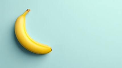 Single Ripe Yellow Banana on a Clean Blue Background with Copy Space