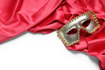 Red velvet curtain with masquerade mask isolated on white background
