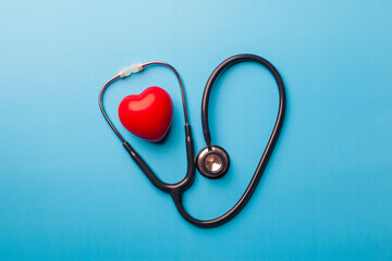 top view, Red heart shape exercise ball with doctor physician's stethoscope on blue background. hospital life insurance concept, world heart health day. doctor day