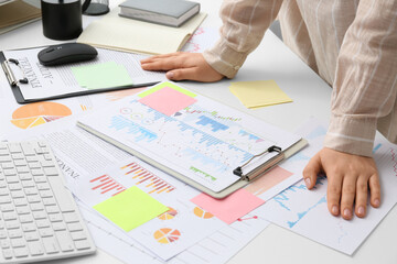 Woman with business charts working at table in office, closeup