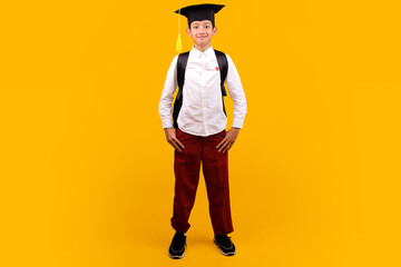Full Body Of Confident Young Student Wear Backpack And Graduation Cap Standing With Hands In Pockets