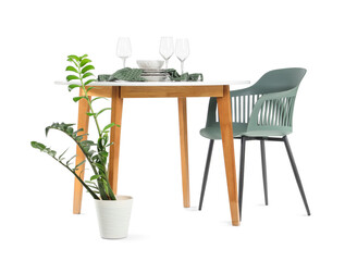 Stylish dining table with glasses, plates and houseplant isolated on white background