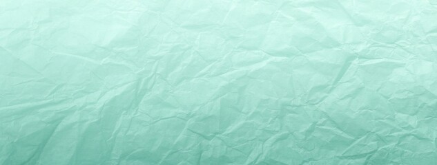 Crumpled mint turquoise pastel paper background with gradient, macro. Texture of wrinkled light...