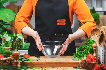 skilled chef beautifully prepares a bowl for fresh veggies, embracing a healthy vegan lifestyle in...