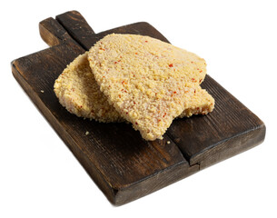 Breaded meat schnitzel fillet with crispy golden coating, raw and frozen, isolated on a rustic wooden board ready for cooking, textured breading, appetizing and delicious appearance