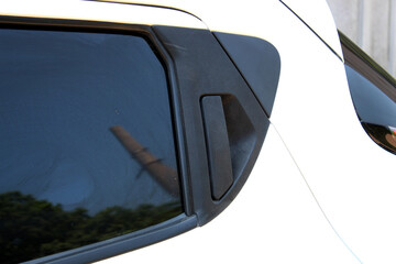 Black door handle of a white car. Modern car door handle. External car door opening handle at the...