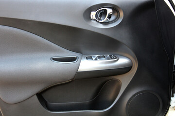Door handle of modern car. New car windows control panel. Grey interior of the luxury modern car....
