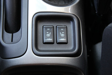 Front seat heating buttons on the cars central console. Seat heating buttons in the car interior. Double seat heating switch in a car.