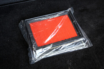 New orange car air filter in package. Auto part car air filter lying on seat. Air filter...