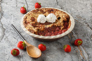 Summer dessert cocoa strawberry cobbler with vanilla ice cream close-up in baking dish on table. horizontal