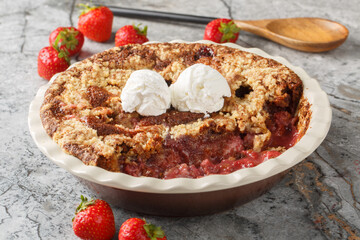 Homemade cocoa strawberry cobbler with vanilla ice cream close-up in baking dish on table. horizontal