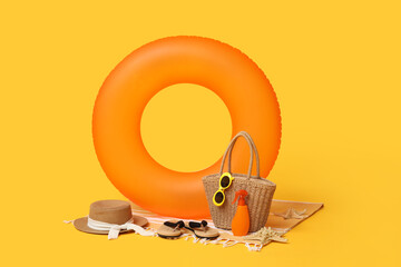 Inflatable ring and beach accessories on orange background, closeup