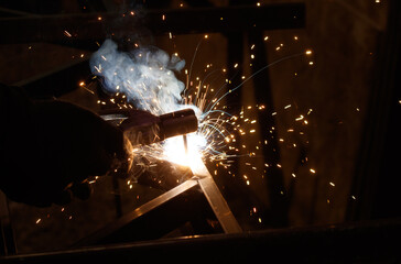 A man is welding metal with sparks flying