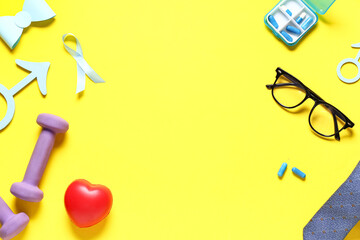 Male sign, ribbon, heart, pills and male accessories on yellow background. Prostate cancer...