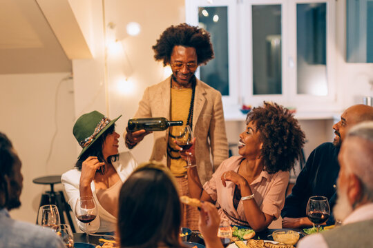 Group of friends sharing wine and laughter indoors