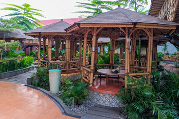 tranquil outdoor restaurant with bamboo gazebos, lush greenery, and a cozy, natural ambiance.