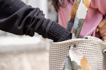Close Up Of Hand In Black Glove Inside A Knitted Bag