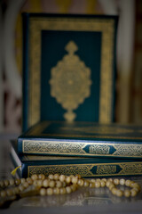 Holy quran and prayer beads on dark background