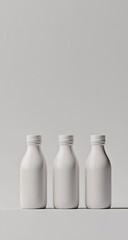 Three plain white bottles, standing upright on a light gray surface