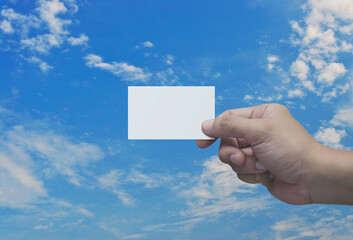 Man hand holding blank white business name card in fingers over blue sky, Business communication concept
