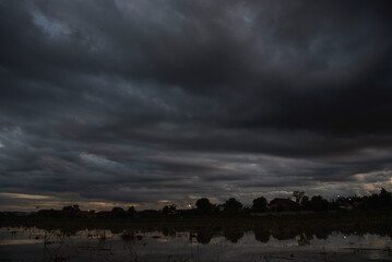 Dark rain cloud dramatic sky summer tropical thunder storm sky and fluffy black darkness cloud...