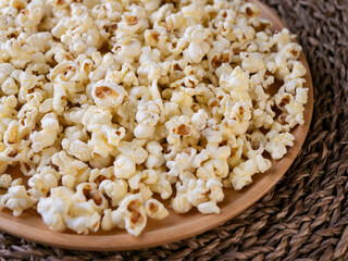 Butter salted popcorn on wooden table.