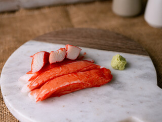 Fresh crab sticks surimi set on white plate with wasibi.