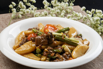 Braised pork with beans and yam fish on a white porcelain plate