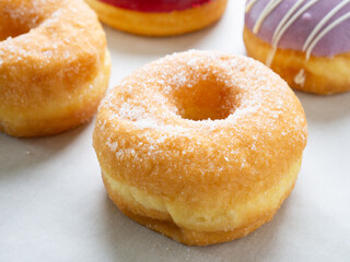 Donuts with different colorful icing designs on a white background.