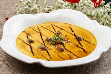 Steamed egg with clam meat and seafood sauce on a white porcelain plate