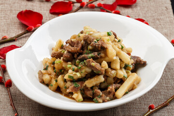 White porcelain plate with beef stewed with onion and potatoes