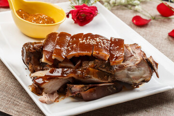 Crispy roasted pork knuckle on white porcelain plate