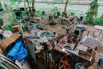 A cluttered outdoor workspace in Montreal, Quebec, Canada, featuring metalworking tools, scrap...