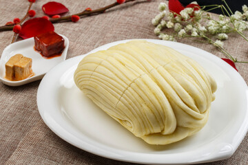 Freshly steamed sesame oil flower rolls on a white porcelain plate