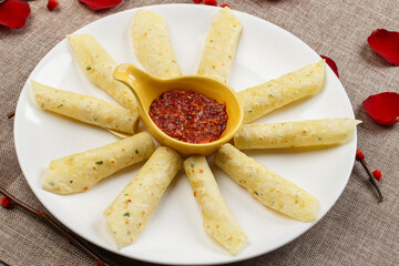 Tortilla chips with dipping sauce on a white porcelain plate