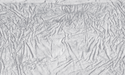 plastic transparent cellophane bag on white background. The texture looks blank and shiny. The plastic surface is wrinkly and tattered making abstract pattern	