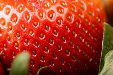 Macro shot of a fresh strawberry showing seeds and texture in extreme detail. Bright red color and natural hair-like fibers visible in high resolution.