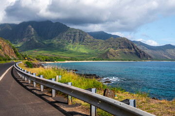 Obraz premium Dramatic cliffs and lush green valley meet the Pacific Ocean on Oahu’s remote west coast, near Waianae.