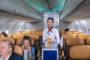 Flight attendant is serving fruit juice to the customer for in flight meal catering, airline travel...