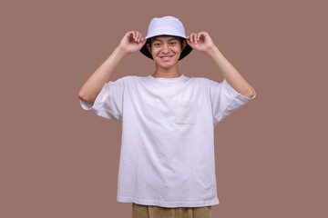 Asian Man in a White Bucket Hat and T-Shirt Against a Beige Studio Background