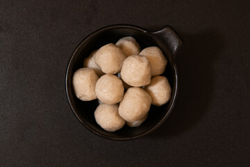 A bowl filled with appetizing fish balls on a dark background