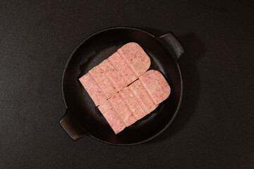 Sliced Spam on a Black Plate