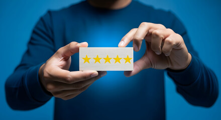 Man in blue shirt holding a card with five yellow stars, symbolizing top rating or excellent feedback on a bright blue background.