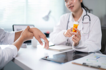 A woman doctor is holding a bottle of medicine and talking to a patient