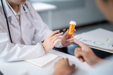 A doctor is showing a patient a bottle of pills