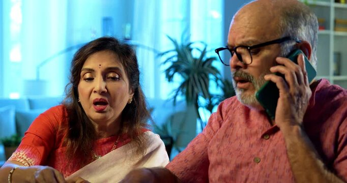 Senior couple and cyber scam while making online payment using computer at home, retired Indian husband wife calling customer care or police after facing digital fraud, financial scam, monetary loss