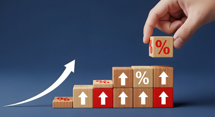 Hand stacking wooden blocks with percent signs and upward arrows, forming a rising graph, symbolizing financial growth and investment success on blue.