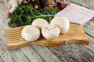 White champignon mushrooms heap over board