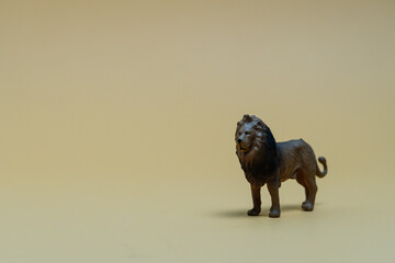 Toy lion on neutral background for child safety message. Plastic lion toy symbolizing strength, protection, and hidden threat